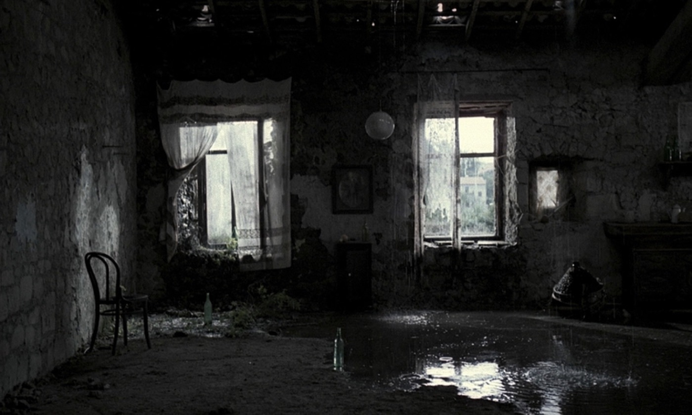 A dark, flooded room lit by two windows